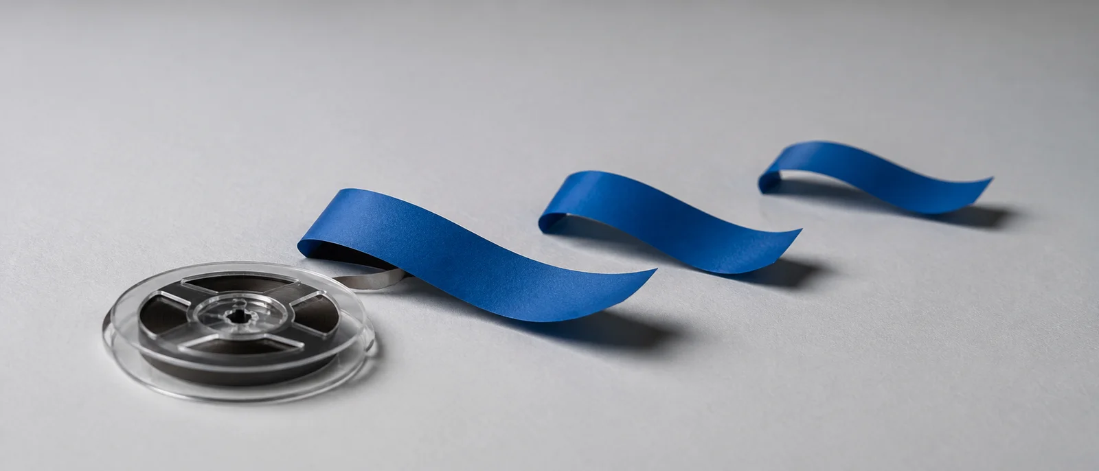 AI-generated sculptural photograph of short blue audio-tape segments representing sentence-based navigation